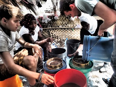 <b>Figure 1.</b> <i>Flotation is taught as part of the field school at Songo Mnara run through Rice University.</i> From left: Dan Miller (University of York); Selena, a Tanzanian student from University of Dar es Salaam; Mariam Mgusi (Antiquities, Tanzania); Matthew Knisley, PhD student, University of Chicago (Image Copyright: S. Walshaw).